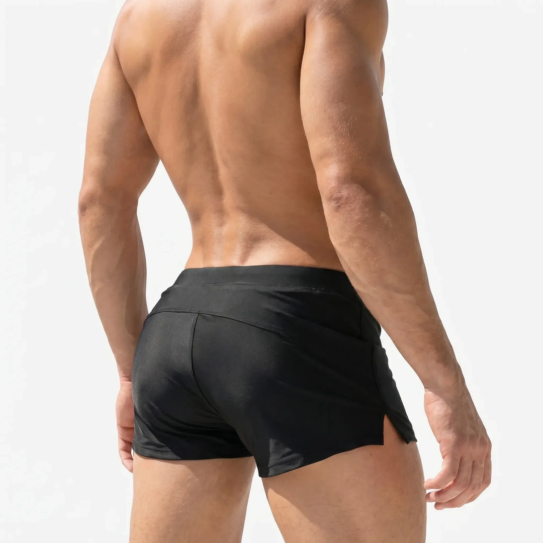 Athletic men's short swim trunks, quick-dry design for swimming, beach, or active watersports. Adjustable waist.