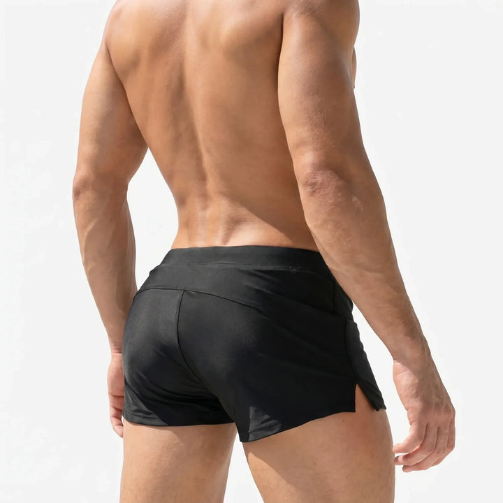 Athletic men's short swim trunks, quick-dry design for swimming, beach, or active watersports. Adjustable waist.