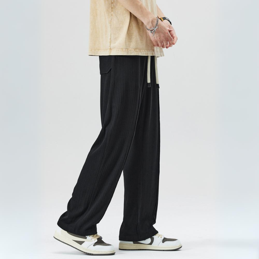 Detail shot of pleats & elastic waist on men's relaxed fit trousers. Comfortable & stylish men's fashion.
