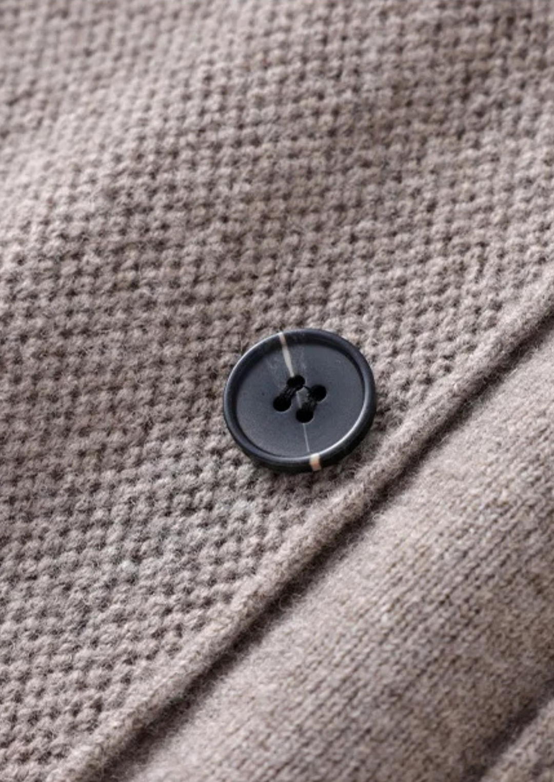 Close-up of a soft knit men's button-up cardigan. High-quality knitwear for all-season comfort & fashion.