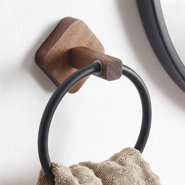 Elegant black aluminum towel ring with light wood accent. Modern Scandinavian wall-mounted bathroom decor.