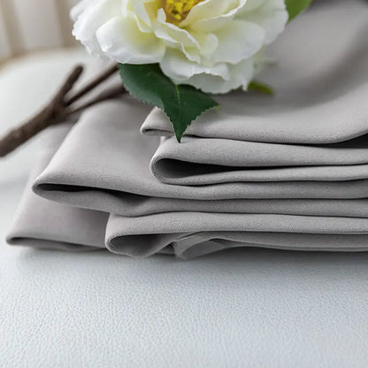Stack of folded thick black blackout curtains, emphasizing their robust room darkening and insulation
