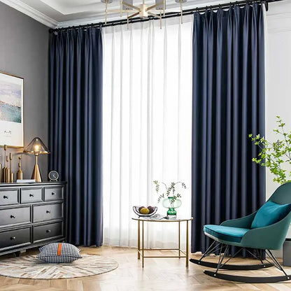 Blackout curtains from an interior view, effectively dimming a bright bedroom with thermal insulated fabric
