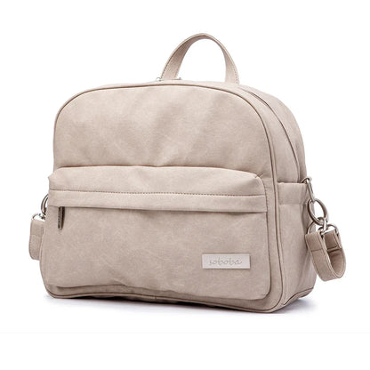 Modern diaper backpack in black PU leather with multiple compartments for stylish parents
