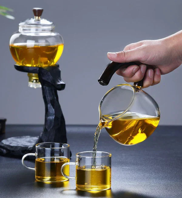 Unisex magnetic tea set in action, pouring freshly brewed loose leaf tea into a glass cup for a modern tea ceremony.