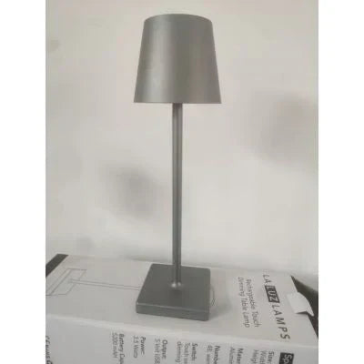 Dimmable LED table lamp, rechargeable and portable, offering adjustable modern lighting for any room or patio.