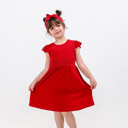 Side view of a mom and baby girl in adorable matching strapless red cotton dresses for summer.