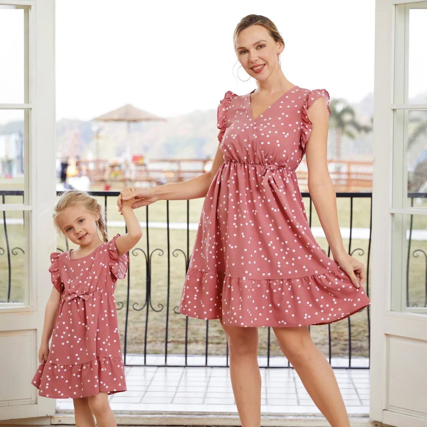 Mom and daughter in matching pink polka dot cross wrap dresses, perfect family summer outfit
