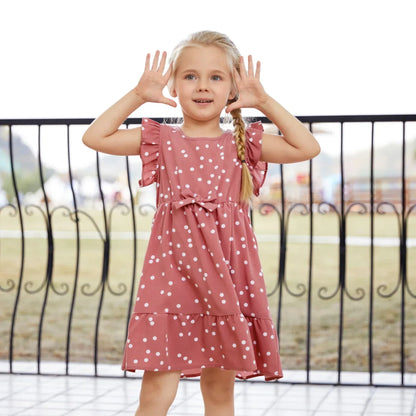 Two girls smiling in their identical pink polka dot cross wrap dresses, perfect for sisters