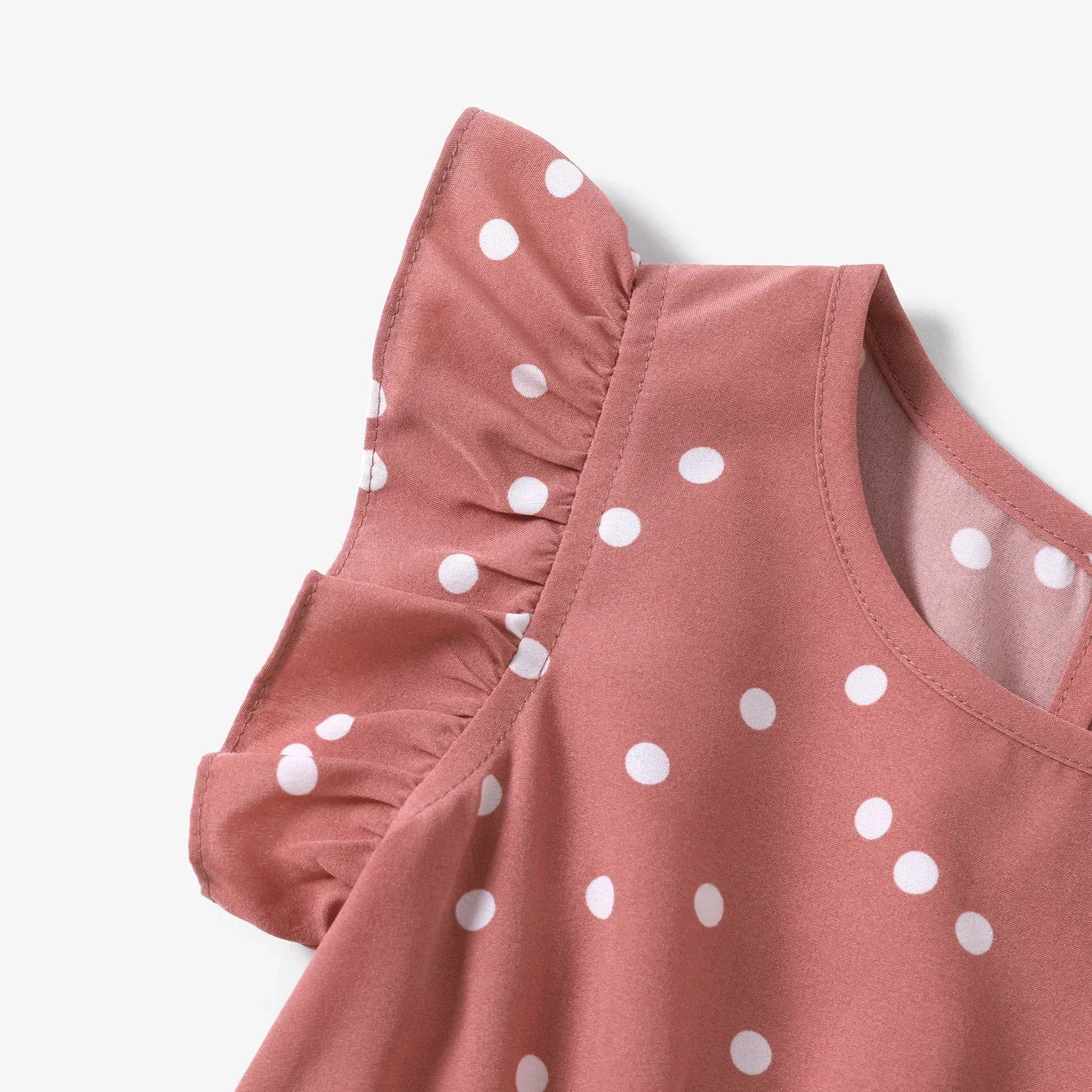 Close-up of the hemline on a knee-length pink dotted cross wrap dress, neat stitching