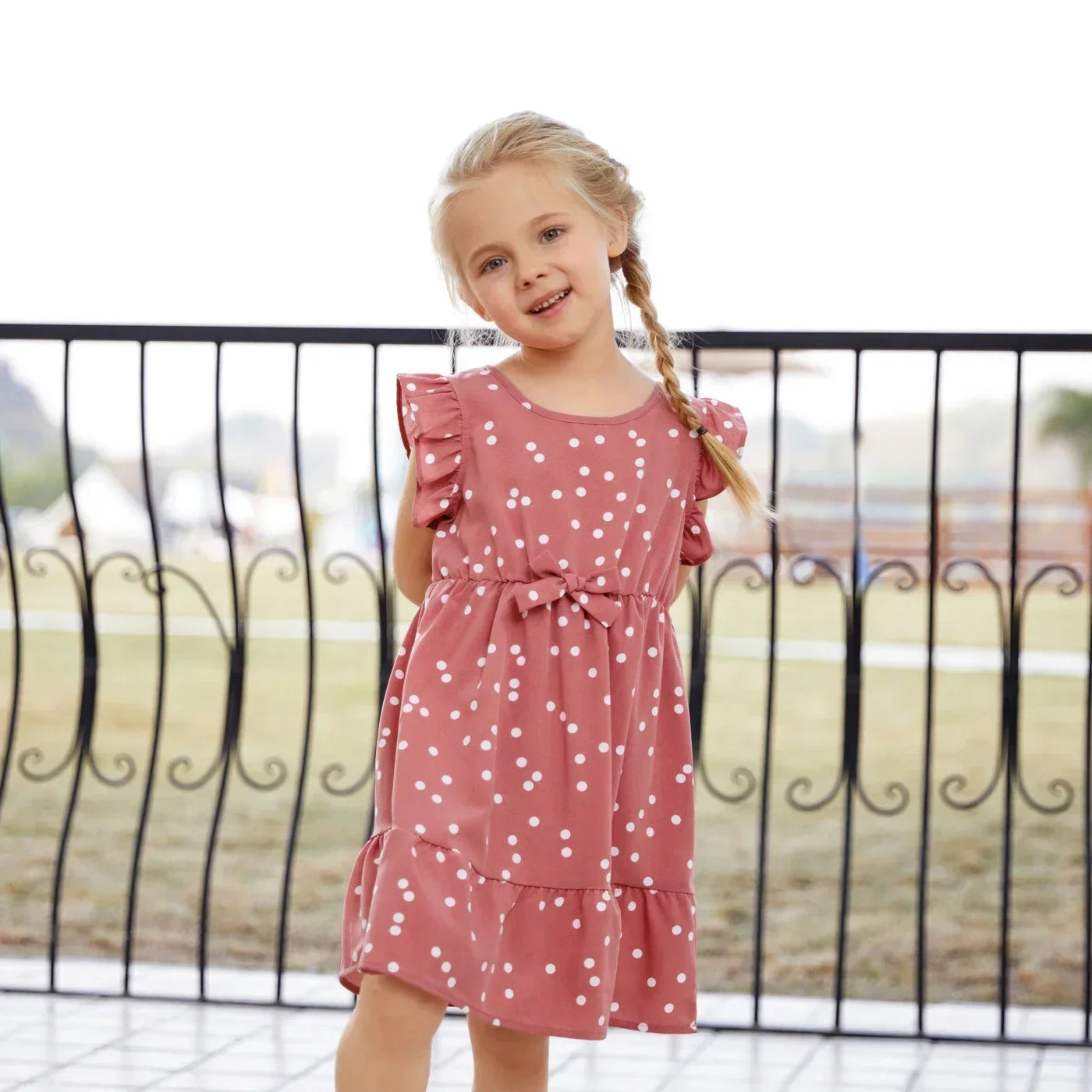 Women's pink dotted cross wrap dress, an elegant and flowy summer outfit for moms
