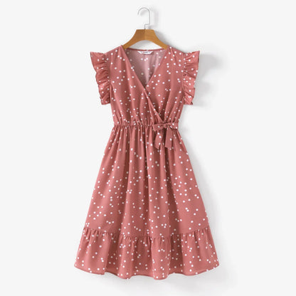 Close-up of pink dotted fabric on a cross wrap dress, highlighting the pattern and texture