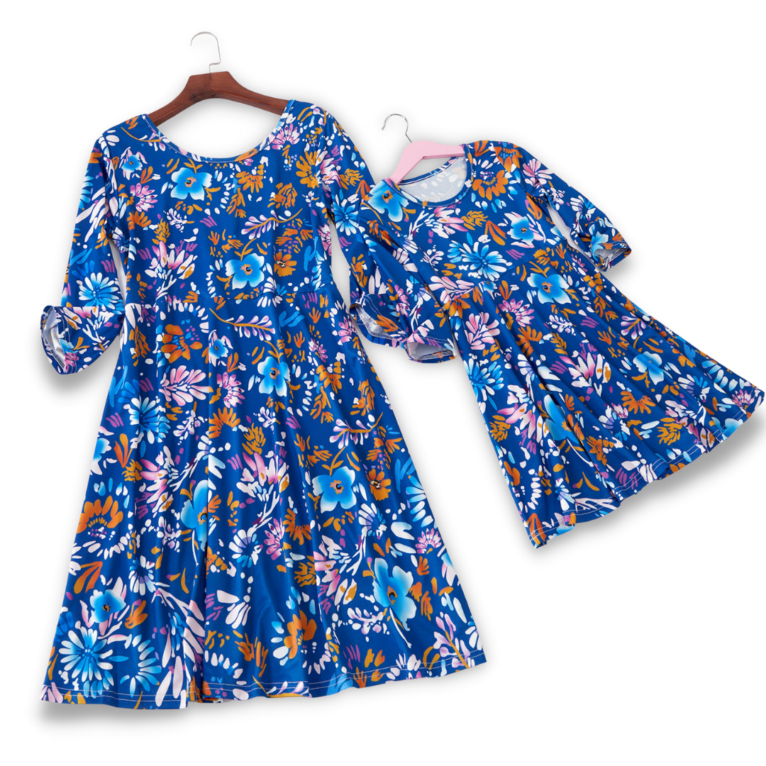 Matching mother daughter casual blue floral summer dresses, full length shot.