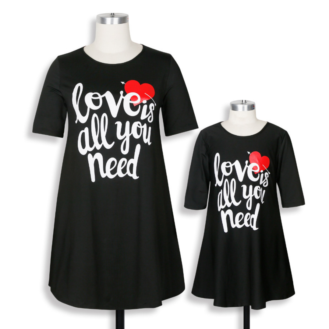 Mother and daughter in 'Love is All You Need' matching casual tee dresses, ideal for a summer family photoshoot.