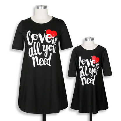 Mother and daughter in 'Love is All You Need' matching casual tee dresses, ideal for a summer family photoshoot.