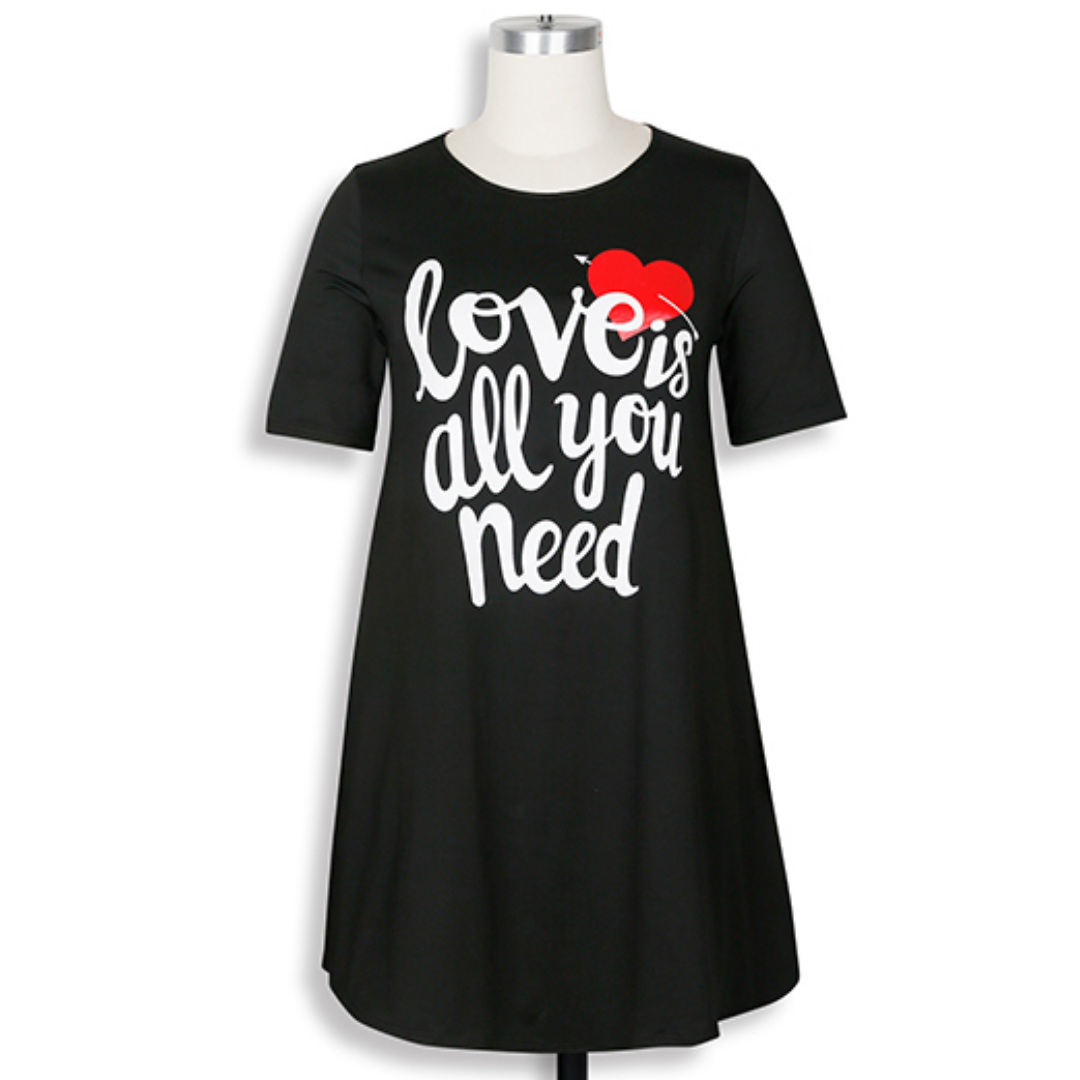 Closeup of 'Love is All You Need' graphic on matching mommy and me tee dresses, soft cotton blend fabric.