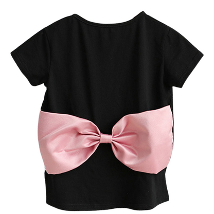 Close-up of a pink baby girl's dress with a big bow, part of a mommy and me matching outfit set.