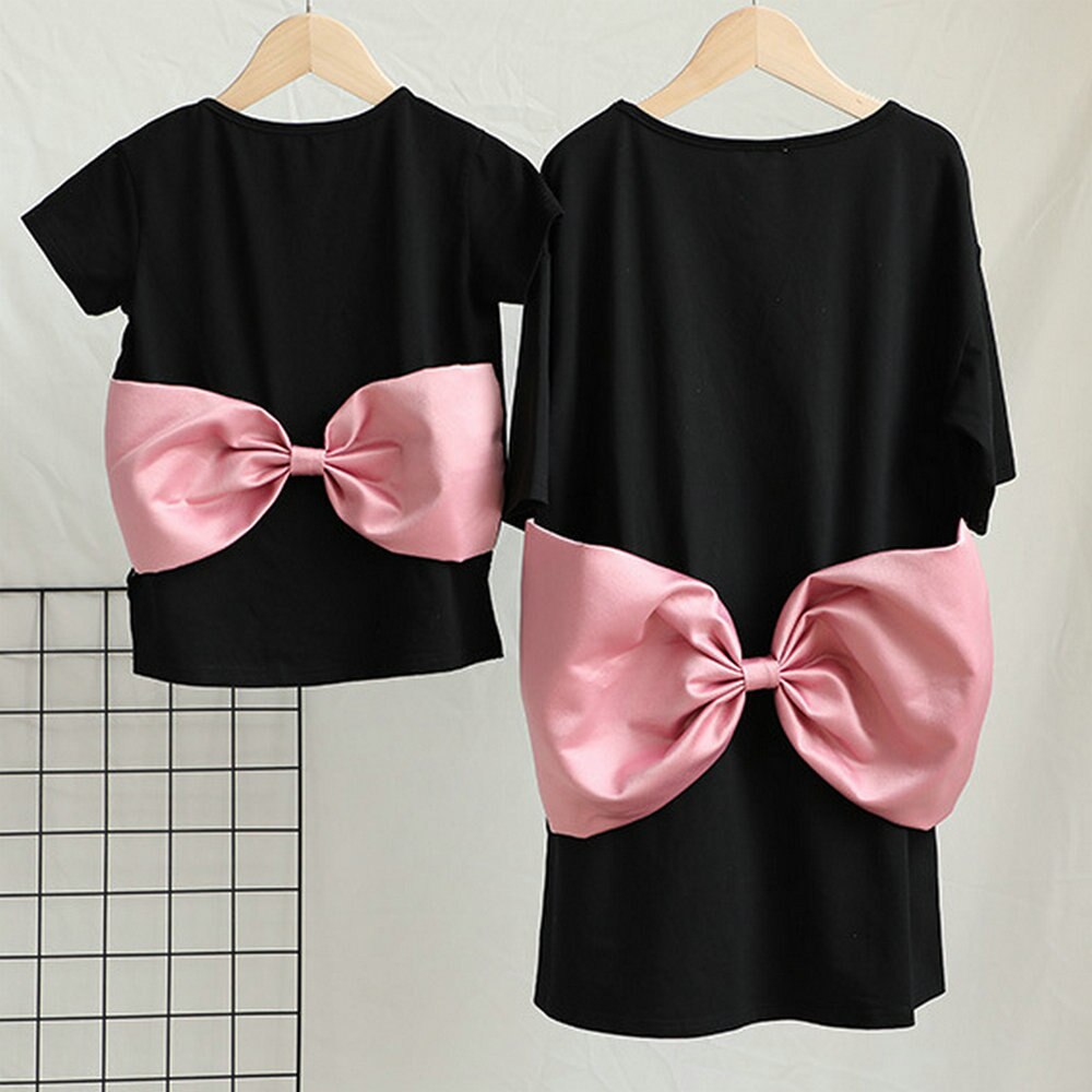 Mom and baby girl in coordinating pink dresses with big bow design, perfect cotton blend outfits.