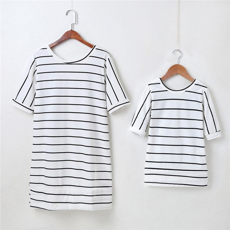 Two striped dresses, one for women and one for girls, both featuring decorative angel wings.