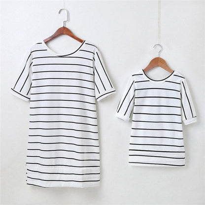 Two striped dresses, one for women and one for girls, both featuring decorative angel wings.