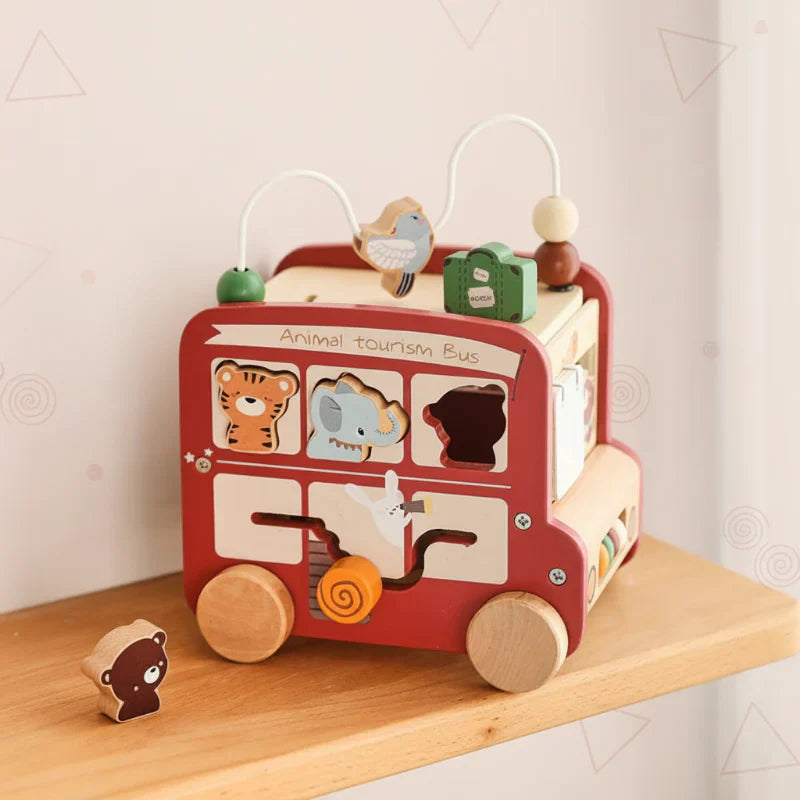 Toddler playing with a sustainable wooden montessori activity bus, enhancing early learning.