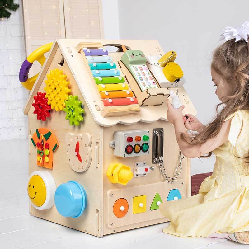 Montessori wooden busy house toy for toddlers, developing fine motor skills and sensory exploration.