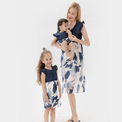 Close-up of mother and daughter matching floral dresses with elegant ruffle sleeves and vibrant print