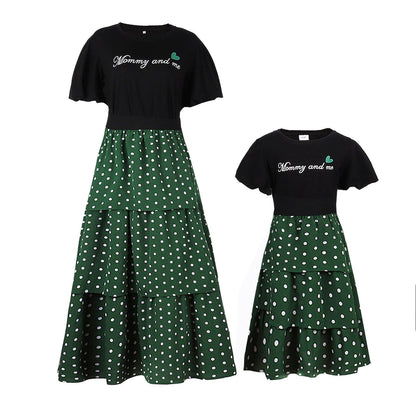 Close-up of a white letter print t-shirt for a child, paired with a black and white polka dot skirt.