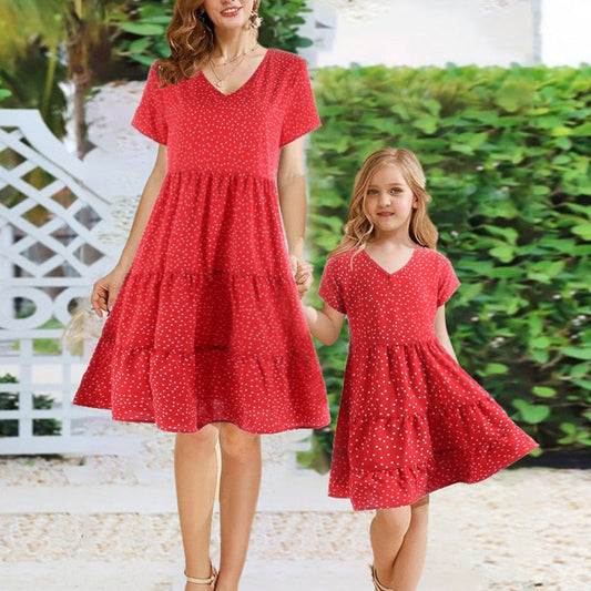 Mother and daughter in matching pink V-neck short sleeve dresses, enjoying a summer day