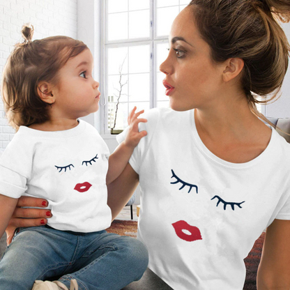 Mother and daughter matching white cotton t-shirts with red lips and lashes print, perfect for family casual wear.