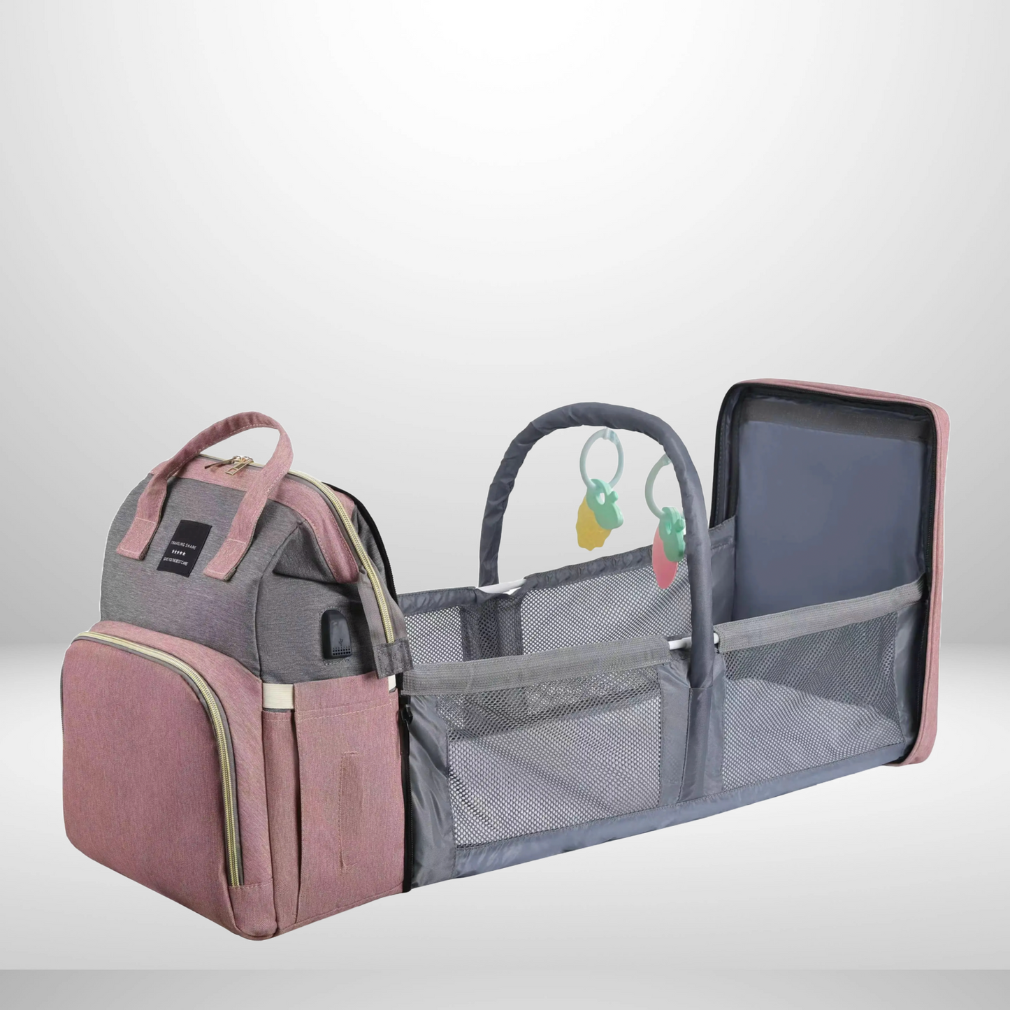 Diaper bag fully extended into a comfortable portable changing bed, surrounded by baby essentials pockets