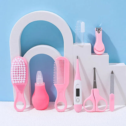 Close-up of baby health care kit tools: soft-bristle brush, comb, and nasal aspirator