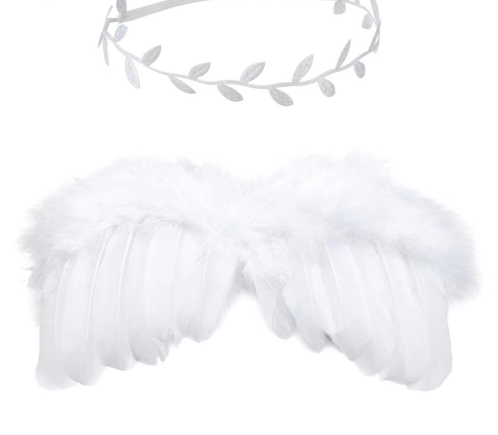 Infant photography focus: close-up on angel feather wings and intricate flower headband detail