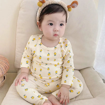 Flat lay of a baby cotton top and pant set in a neutral color, essential infant wear.