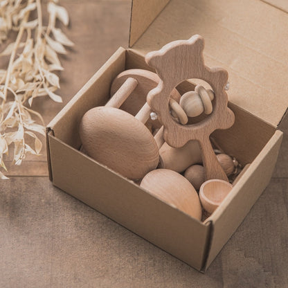 Cozy baby blanket paired with a wooden rattle and grooming tools in a thoughtful gift set