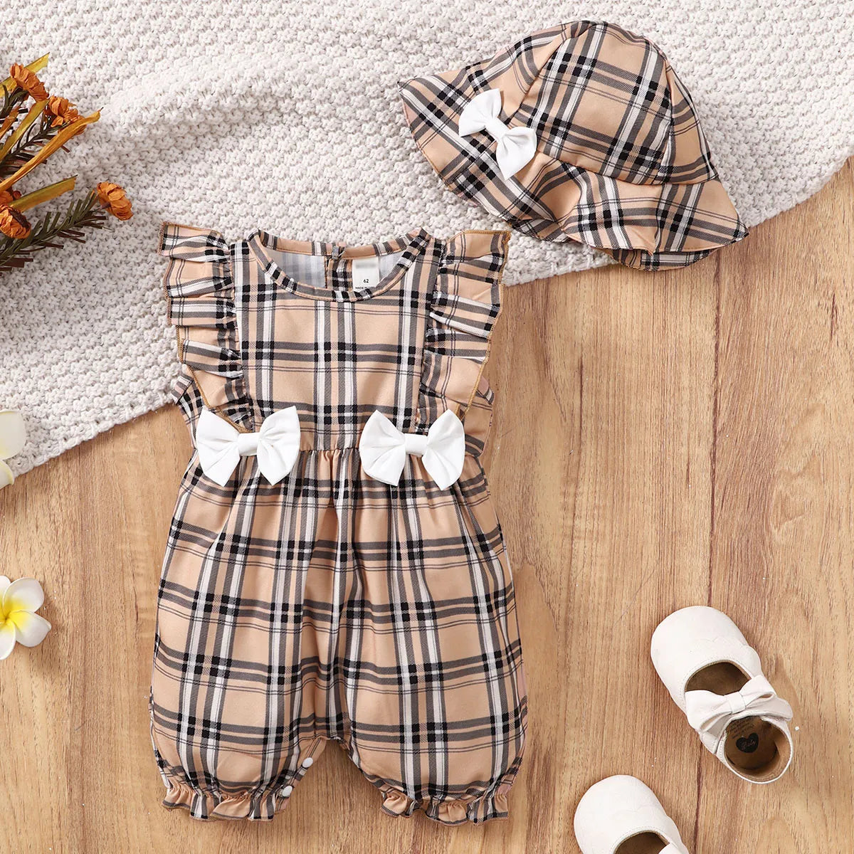 Back view of a baby girl's plaid romper, detailing the easy snap closures for quick changes.