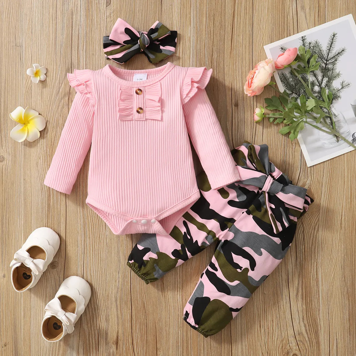 Newborn baby girl in cozy pink 3-piece outfit set, perfect for infants.