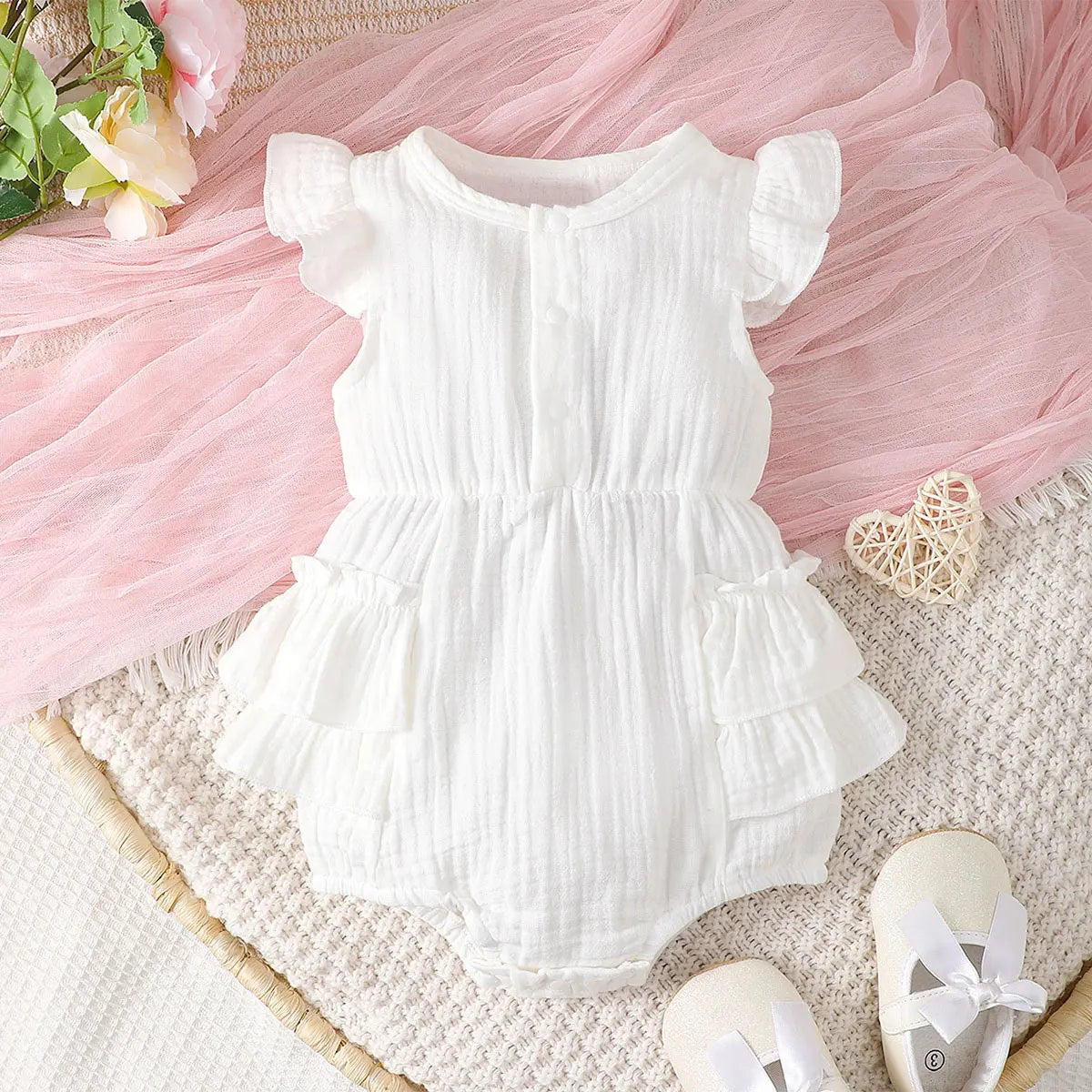 Newborn baby girl in white cotton halter dress with delicate lace trim, perfect infant summer outfit.