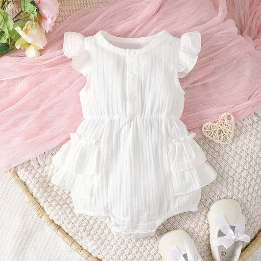 Newborn baby girl in white cotton halter dress with delicate lace trim, perfect infant summer outfit.