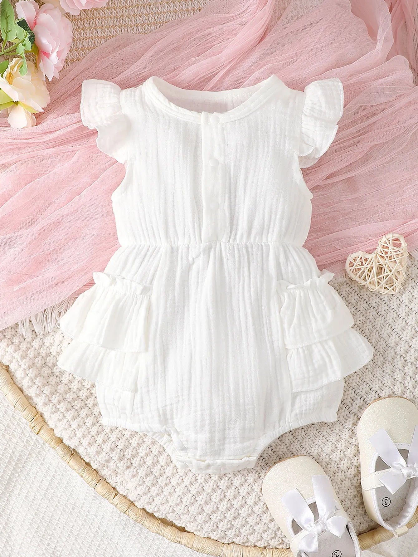 Back view of a white halter newborn dress, showing the tie closure and flowy skirt design.