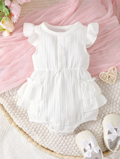 Back view of a white halter newborn dress, showing the tie closure and flowy skirt design.