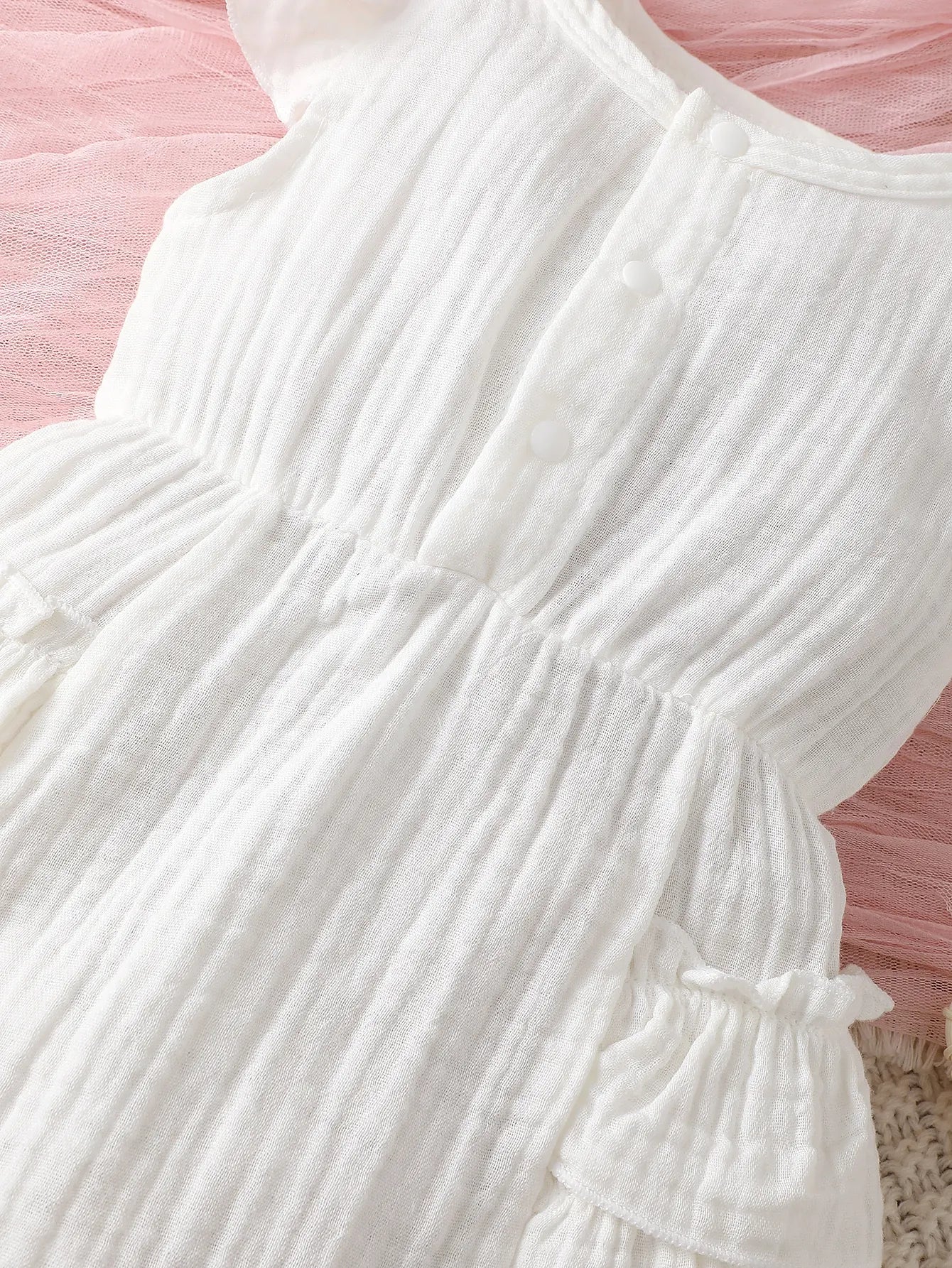 White cotton halter dress on a baby girl mannequin, showcasing its cute and classic summer outfit appeal.