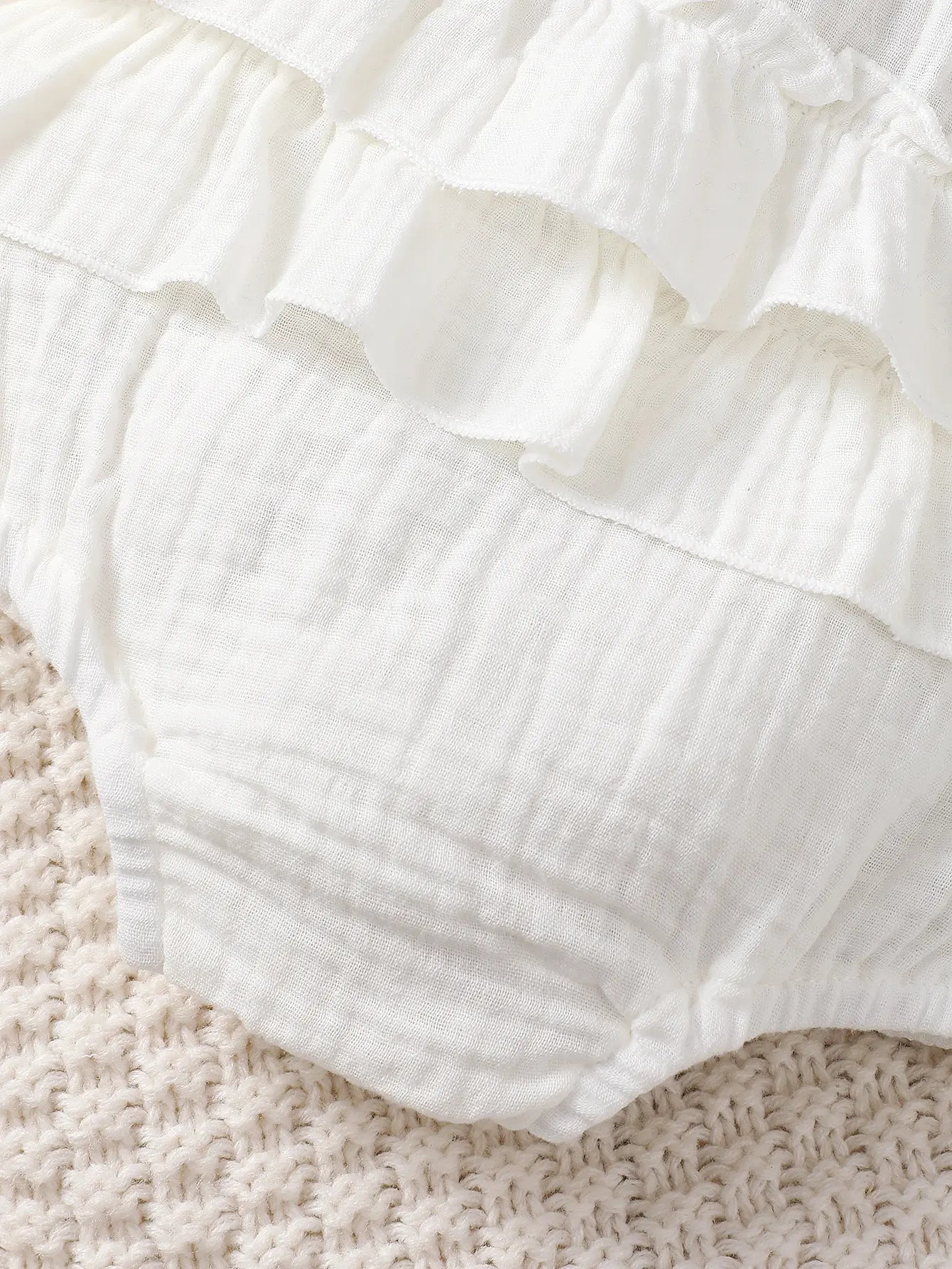 Soft white halter dress for newborn baby girls, a perfect and comfortable infant summer clothing option.
