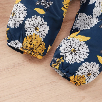 Close-up of a baby girl ruffle bodysuit with snap closures, part of a 3-piece infant clothing set.