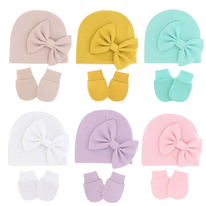 Newborn baby girl's pink cotton hat and mitten set, soft infant apparel.
