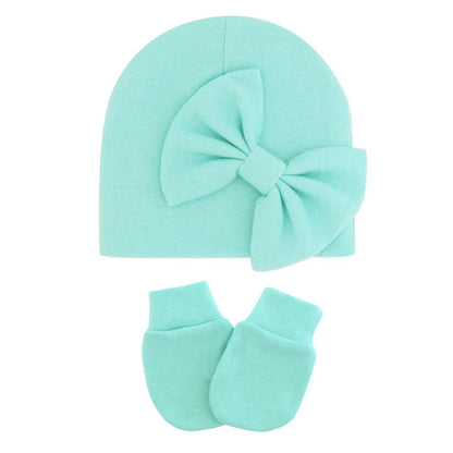 Newborn girl's cotton hat and mittens set, ideal for keeping baby cozy.