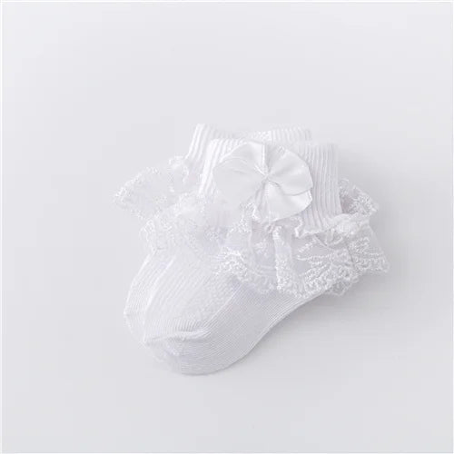 Side profile of newborn girl's lace socks, showcasing the delicate princess bow detail