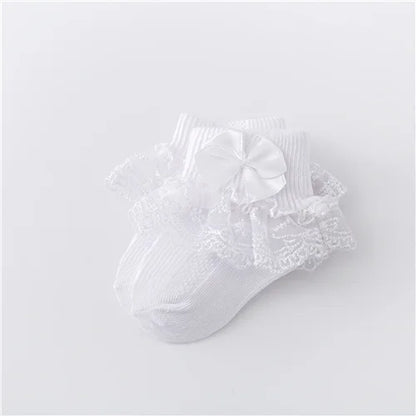 Side profile of newborn girl's lace socks, showcasing the delicate princess bow detail