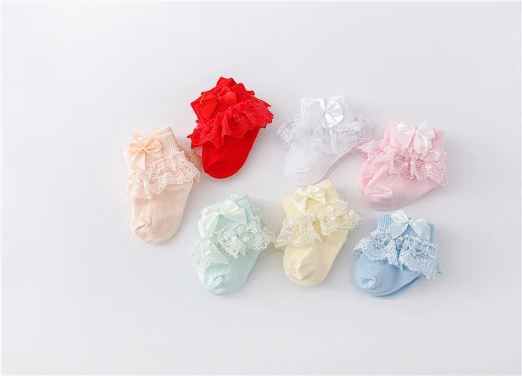 Close-up of the delicate lace pattern and princess bow on a baby girl's sock