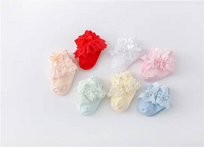 Close-up of the delicate lace pattern and princess bow on a baby girl's sock